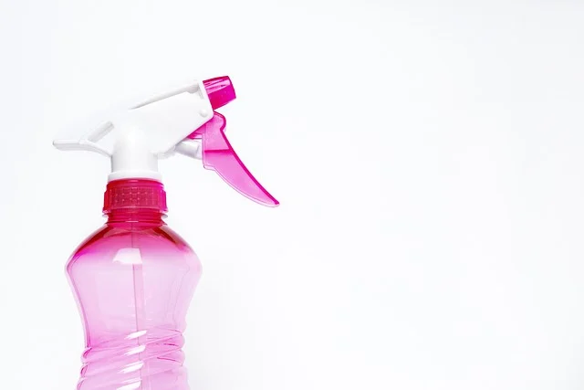 A pink spray bottle on a white background.
