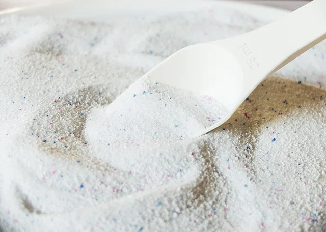 White powder with colorful specks and a measuring scoop